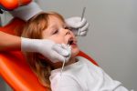 a little girl is getting dental treatment